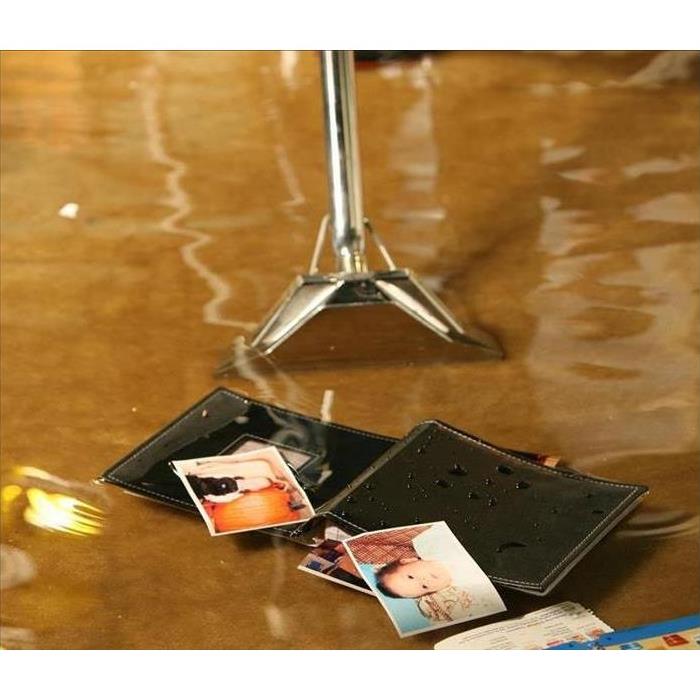 Wallet and pictures floating in home with flood water.