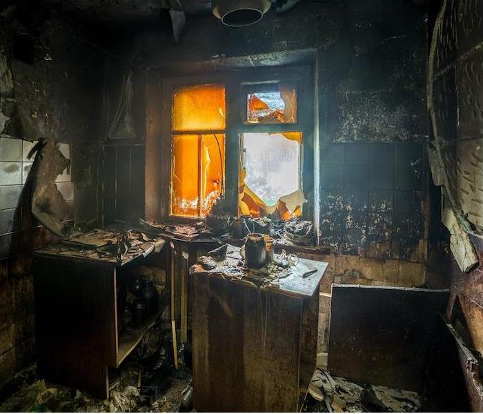 A small interior room showing extensive damage from a recent fire.